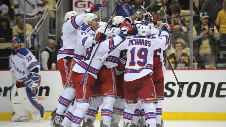The Rangers mob Derick Brassard after his game-winning goal in...