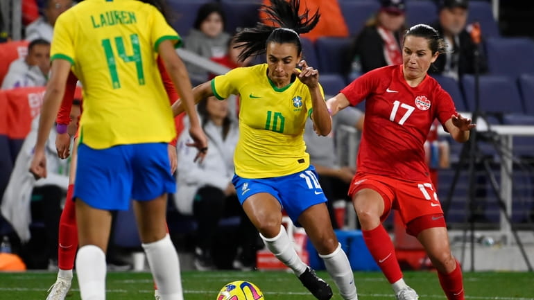 Brazil forward Marta (10) moves the ball past Canada midfielder...
