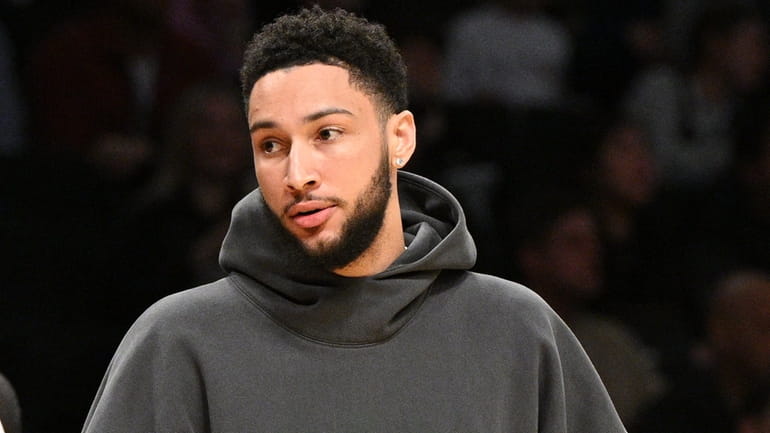 Nets guard Ben Simmons, wearing street clothes, looks on during...