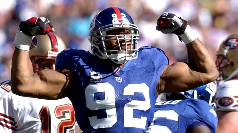 Michael Strahan flexes his muscles after his sack of the...