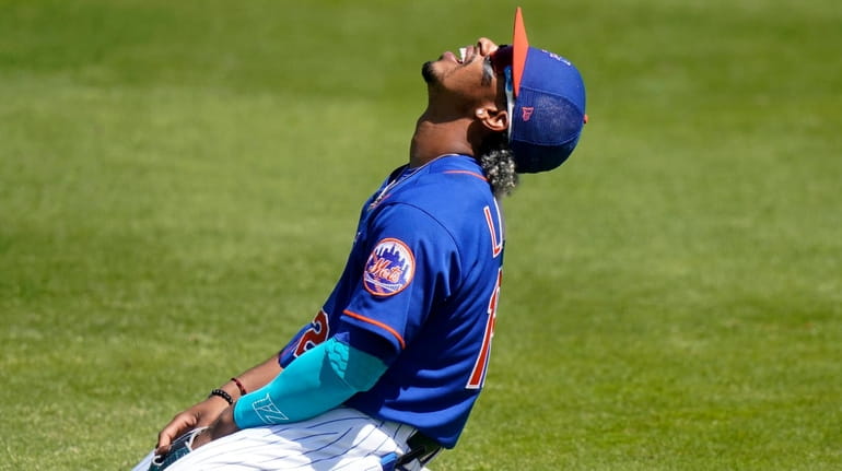 Mets shortstop Francisco Lindor reacts after he can't get to...
