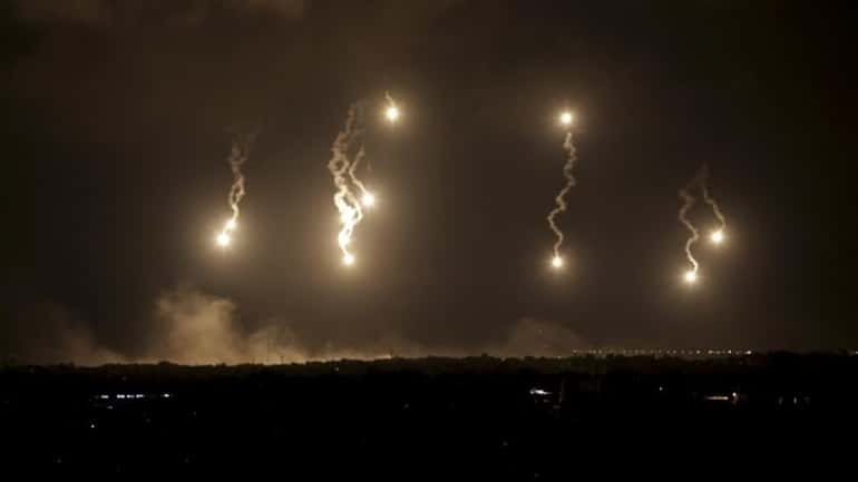 Israeli forces' flares light up the night sky in the...