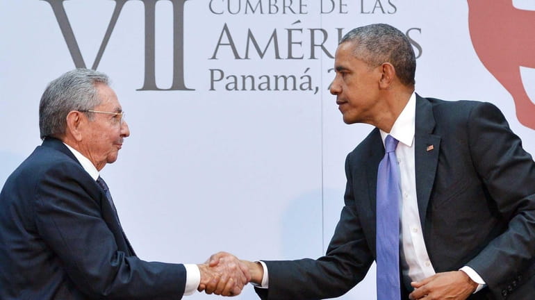 President Barack Obama shakes hands with Cuban President Raul Castro...