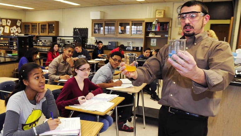 Joseph Vanasco, AP Chemistry teacher, shows his students food dye...