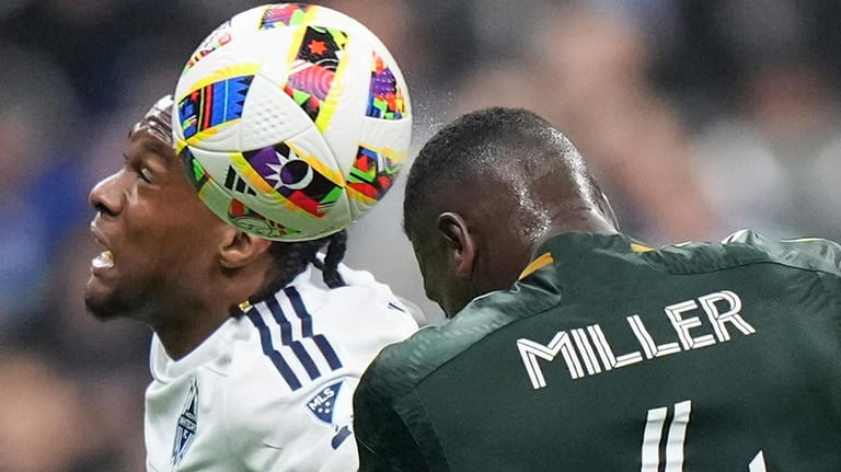 Vancouver Whitecaps' Levonte Johnson, left, and Portland Timbers' Kamal Miller...