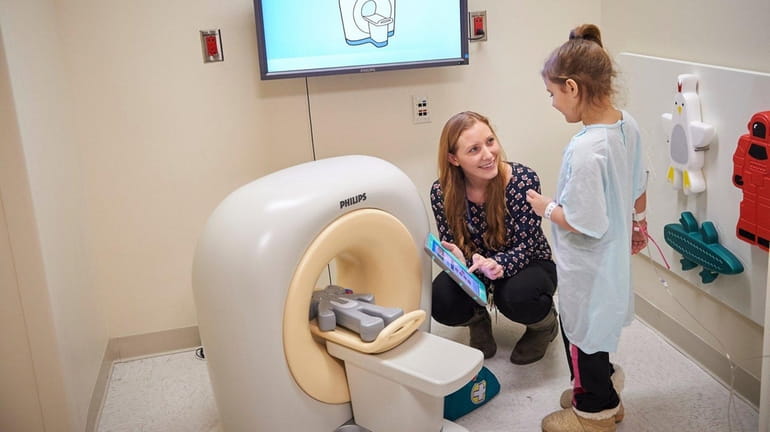 Courtney Giordano demonstrates the Kitten Scanner to a young patient...
