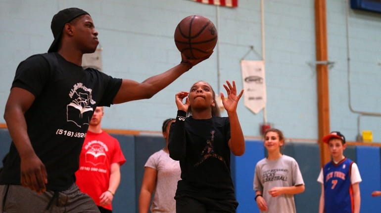 Isaiah Whitehead of the Nets gives a ball to Jada...