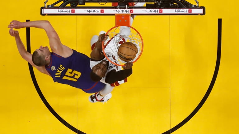 Miami Heat center Bam Adebayo dunks against Denver Nuggets center...