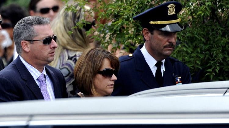 Warren Hance, left, and Jackie Hance leave a funeral Mass...