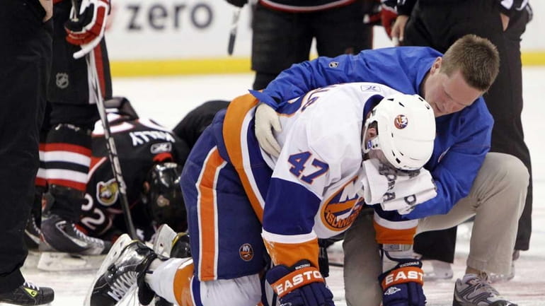 The Islanders' Andrew MacDonald (47) and Ottawa's Chris Kelly recover...