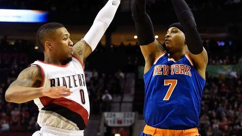 Knicks forward Carmelo Anthony shoots over Trail Blazers guard Damian...