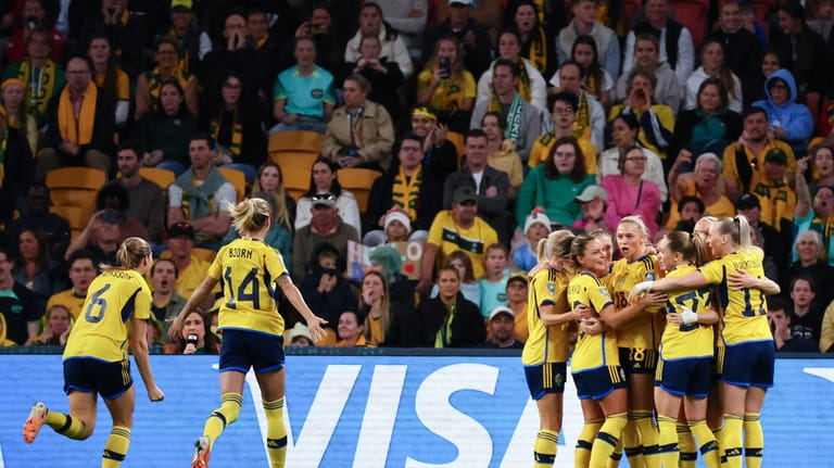 Sweden celebrate after scoring their first goal during the Women's...