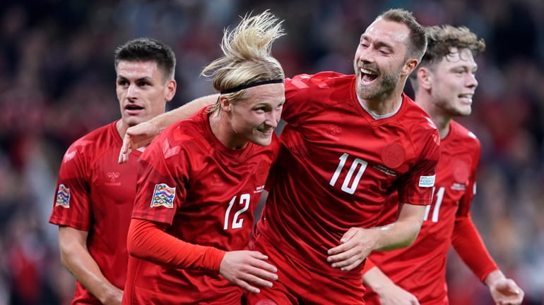 Denmark's Kasper Dolberg, second left, celebrates scoring with teammates Christian...