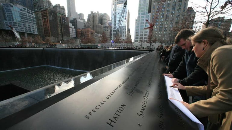 Paige Bachety, of Sayville, traces a name at the 9/11...