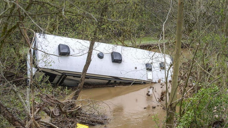 A 40-foot recreational vehicle rests in Smith Creek on Friday,...