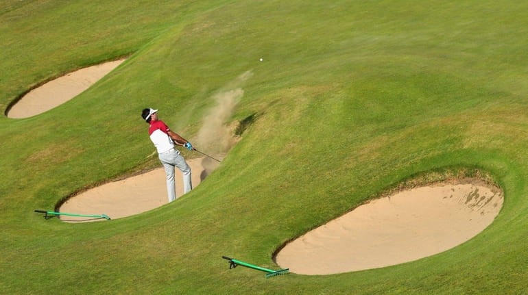 Bubba Watson of the United States hits a bunker shot...