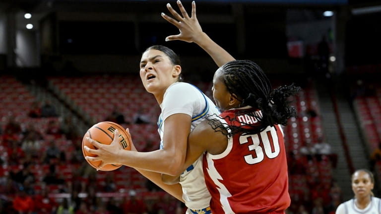 UCLA center Lauren Betts tries to shoot over Arkansas forward...