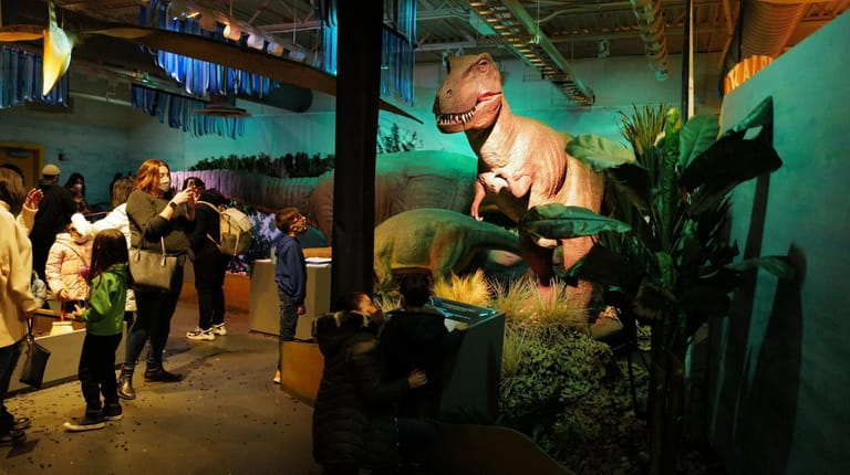 Kids interact with the animatronic dinosaurs at a new exhibit...