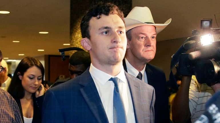Former Cleveland Browns quarterback Johnny Manziel walks with his lawyer...