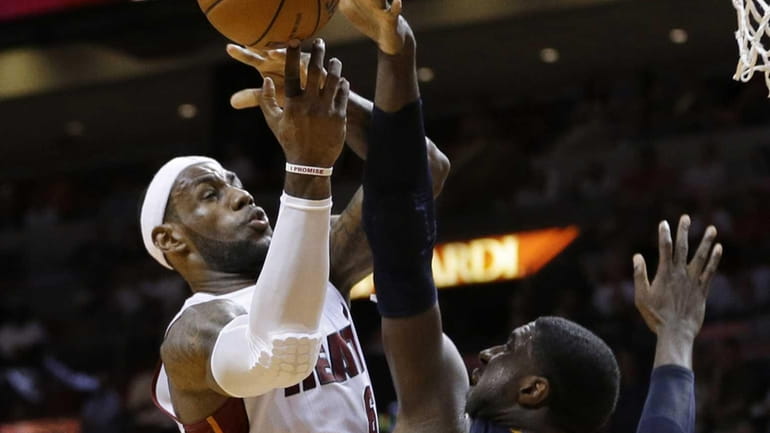 Miami Heat's LeBron James, left, shoots over Indiana Pacers' Roy...