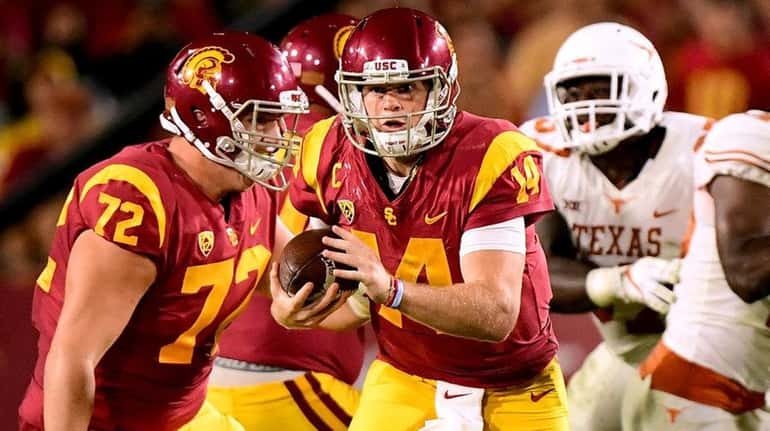 Sam Darnold of the USC Trojans scrambles away from the...