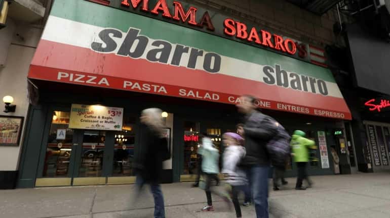 Pedestrians pass by a Sbarro restaurant in Times Square in...