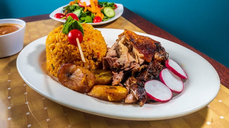 Pernil (roasted pork) with yellow rice and sweet plantains at...