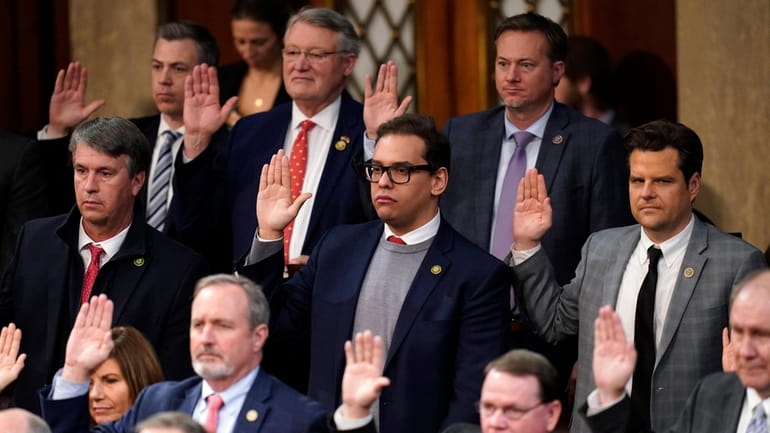 Rep. George Santos (R-N.Y.), center, among others, are sworn in by...