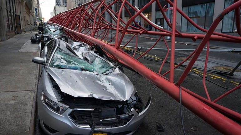 Cars lay crushed in the aftermath of a crane collapse...