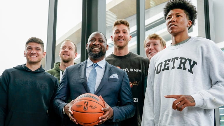 Milwaukee Bucks new head coach Adrian Griffin poses with players...