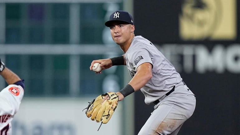 Yankees shortstop Anthony Volpe looks to first after forcing out...