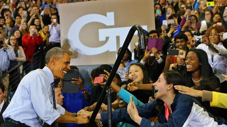 Students reach out for President Barack Obama as he takes...