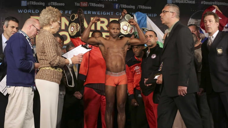 Boxer Guillermo Rigondeaux gestures as he stands on the scale...