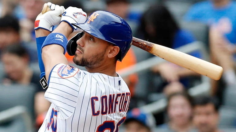 Michael Conforto of the New York Mets follows through on...