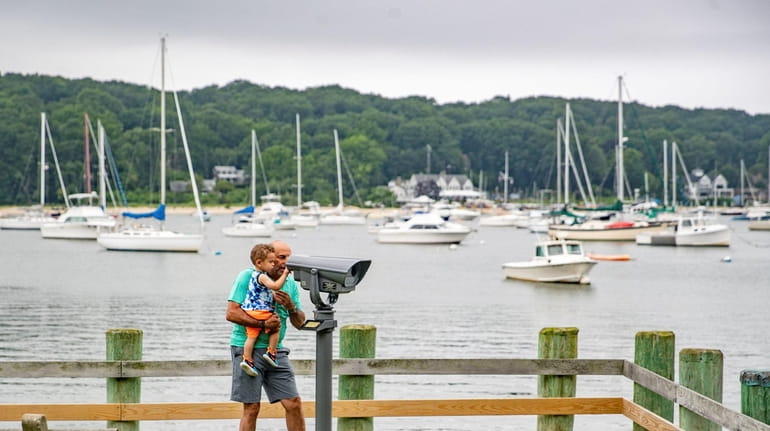A man and his grandson look across Northport Harbor earlier...