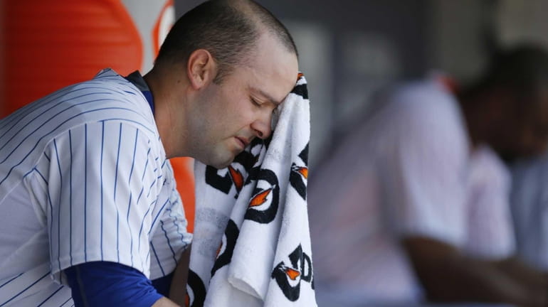 New York Mets starting pitcher Dillon Gee wipes his face...