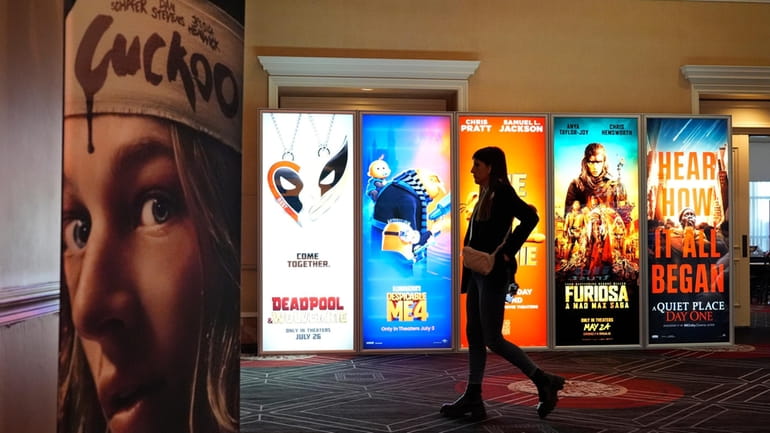 A visitor walks past advertisements for upcoming movies on the...