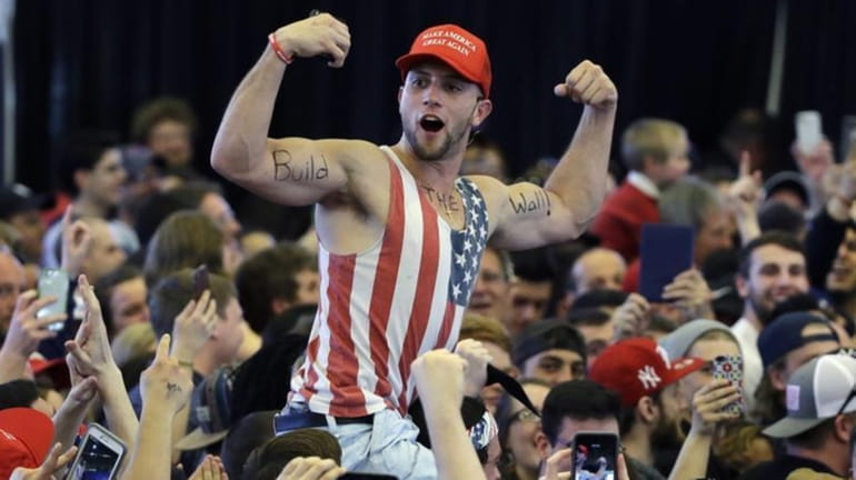 A Donald Trump supporter flexes his muscles with the words...
