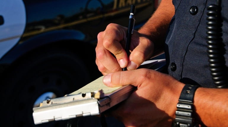 A police officer  writes a ticket.
