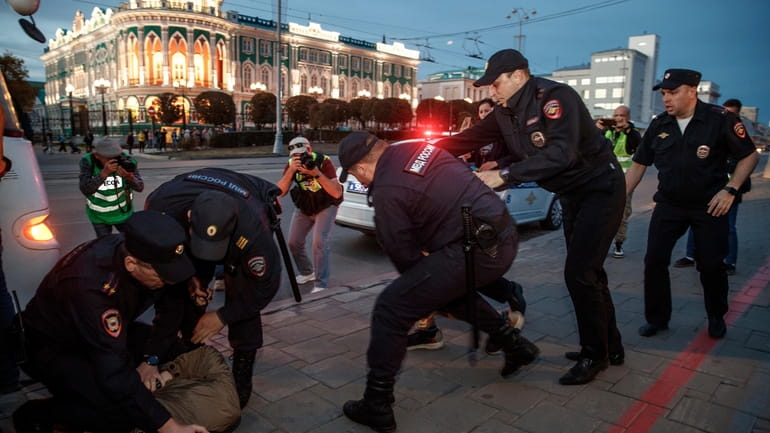 Police tackle demonstrators Wednesday during a protest against President Vladimir...