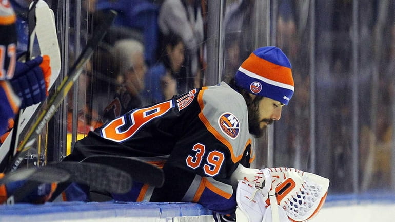 Rick DiPietro of the Islanders looks on from the bench...