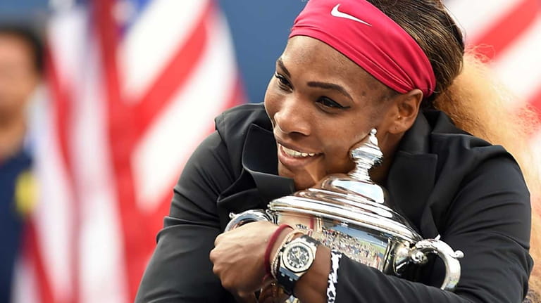Serena Williams holds up the winning trophy after defeating Caroline Wozniacki in...