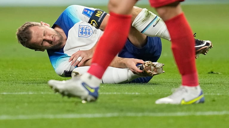 England's Harry Kane grabs his foot after a collision with...
