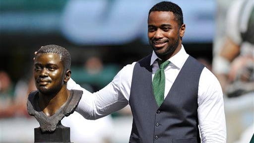 New York Jets' Curtis Martin poses with his bust as...