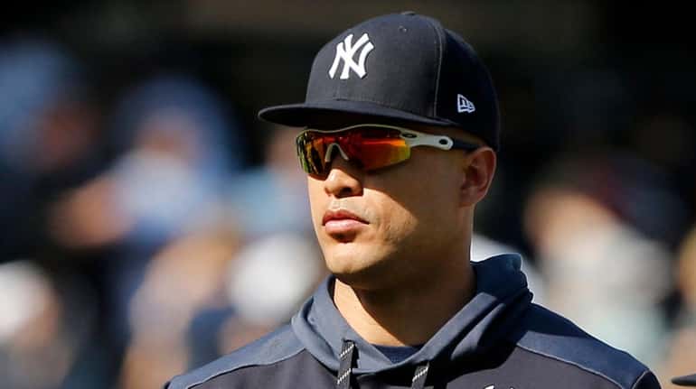 Giancarlo Stanton #27 of the Yankees looks on after a...