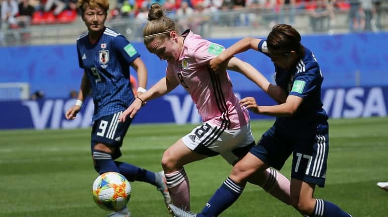 Scotland's Kim Little, center, vies for the ball with Japan's...