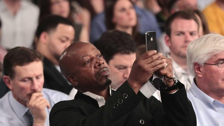 Rapper MC Hammer uses his iPhone during a town hall...