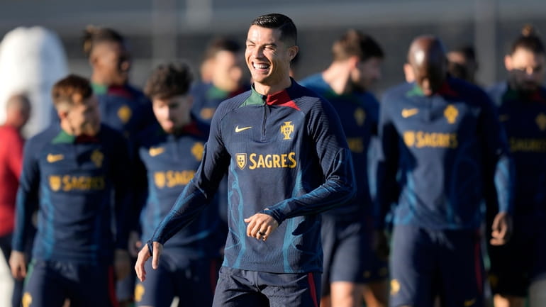Portugal's Cristiano Ronaldo laughs as he arrives on the pitch...