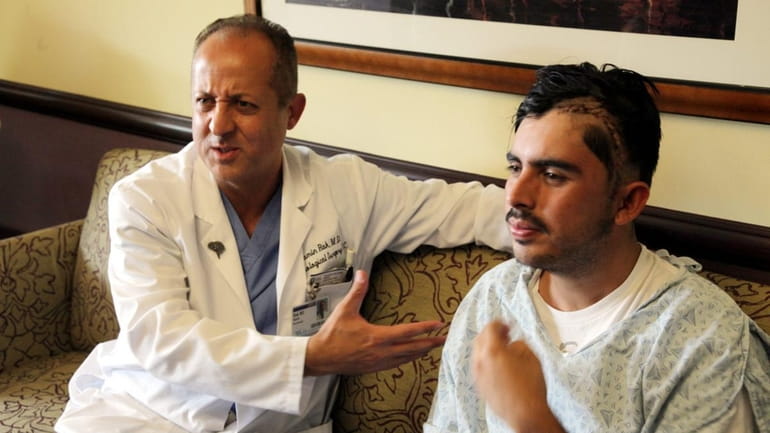 Dr. Ramin Rak, left, talks about a rare brain surgery...