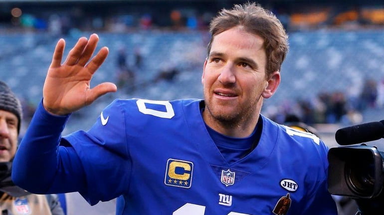 Giants quarterback Eli Manning waves to the fans as he...